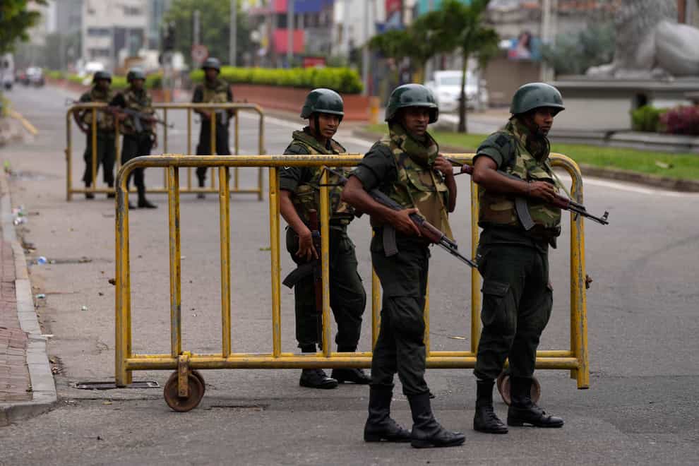 Sri Lankan army soldiers guard a check point outside prime minister’s residence a day after clashes between government supporters and anti-government protesters in Colombo, Sri Lanka, Tuesday, May 10, 2022. Defying a nationwide curfew in Sri Lanka, several hundred protesters continued to chant slogans against the government Tuesday, a day after violent clashes saw the resignation of the prime minister who is blamed, along with his brother, the president, for leading the country into its worst economic crisis in decades. (AP Photo/Eranga Jayawardena)