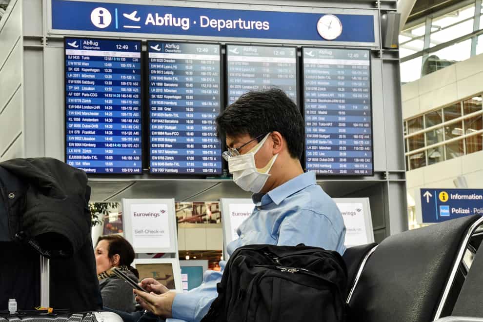 A passenger wearing a face mask waits for his flight at the airport in Duesseldorf, Germany (Martin Meissner/AP)