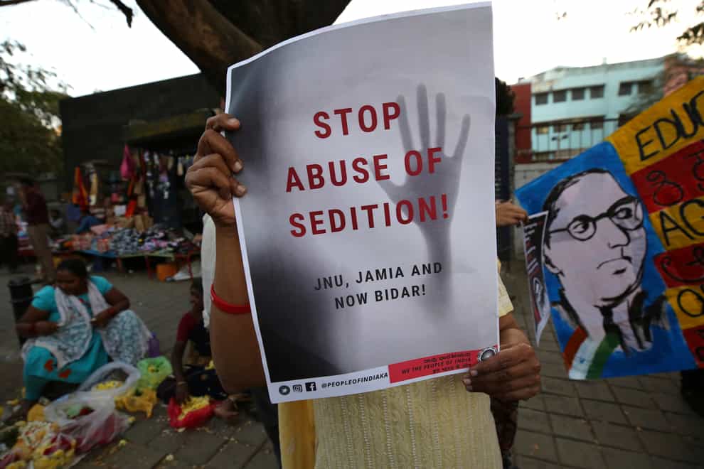 A woman holds a placard protesting against a sedition case in Bangalore, India, in 2020 (Aijaz Rahi/AP)