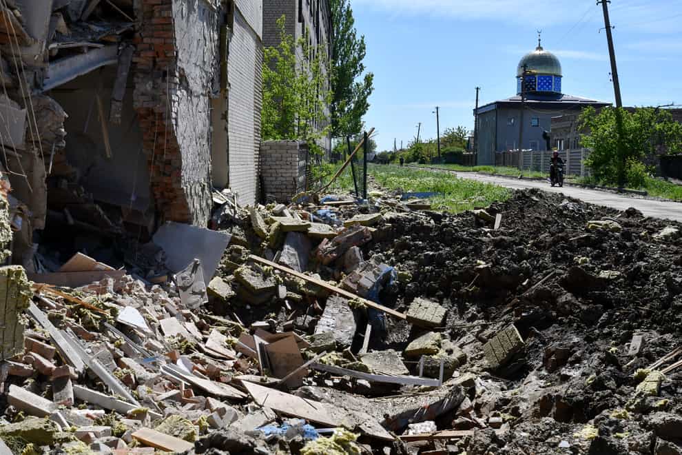 A crater of an explosion after Russian shelling is seen next to a damaged apartment building in Bakhmut, Donetsk region, Ukraine (Andriy Andriyenko/AP)