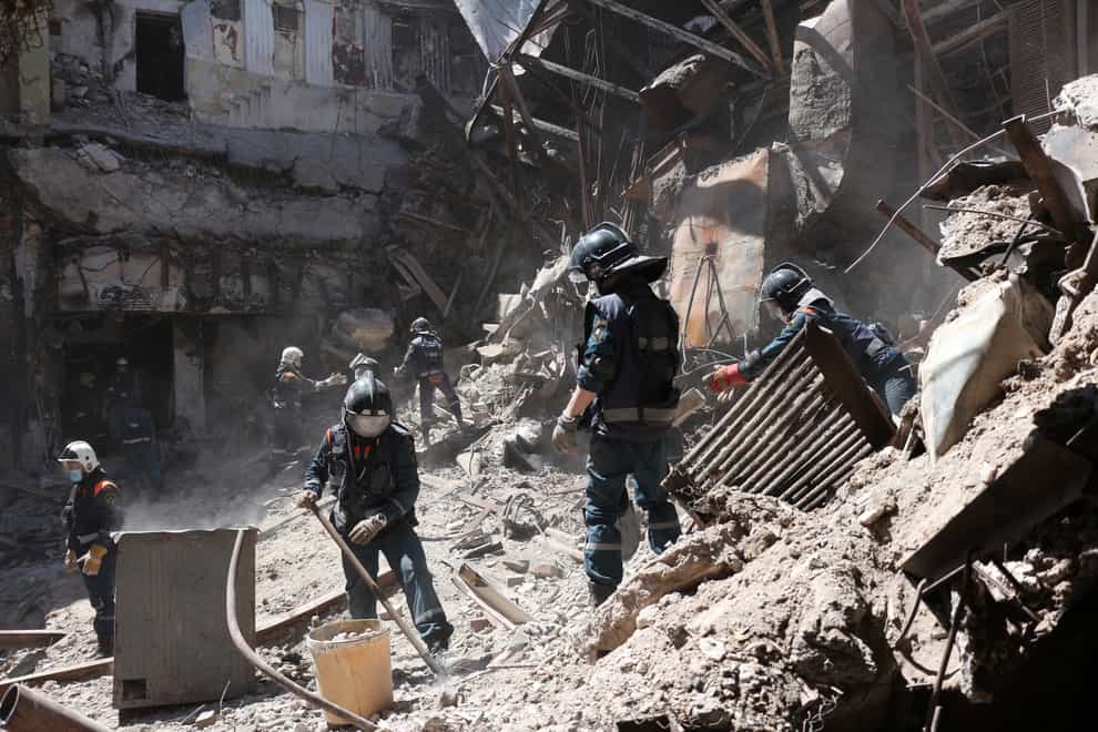 Donetsk People Republic Emergency Situations Ministry employees clear rubble at the side of the damaged Mariupol theater building during heavy fighting in Mariupol, in territory under the government of the Donetsk People’s Republic, eastern Ukraine, Thursday, May 12, 2022. (AP Photo)