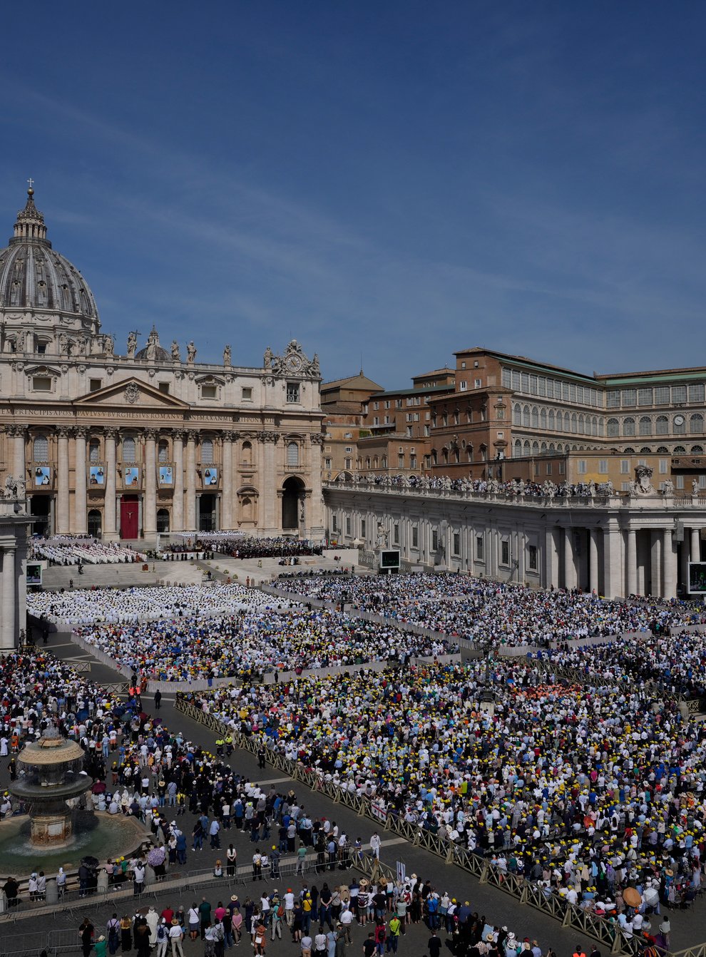The tapestries depicting the 10 new saints hang over a packed St Peter’s Square (Gregorio Borgia/AP)