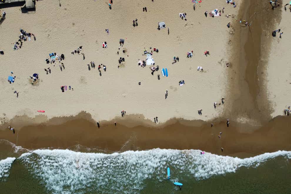 People enjoy the warm weather on Tynemouth Longsands beach, near Tynemouth in Tyne and Wear (Owen Humphreys/PA)