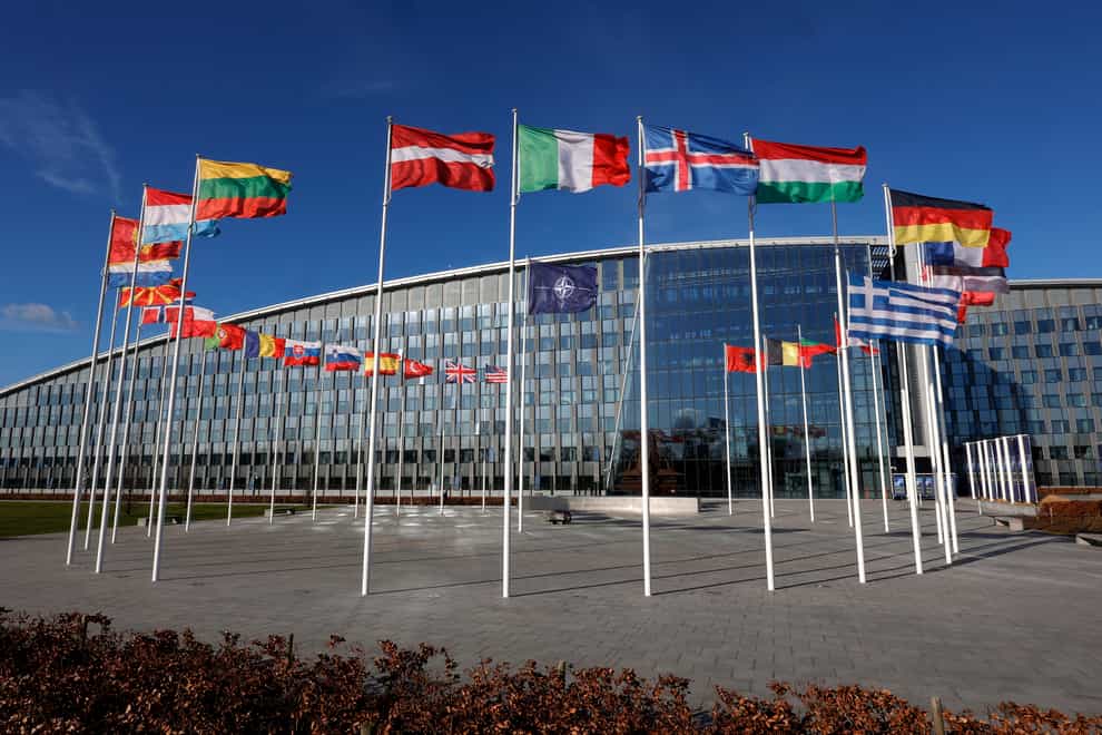 Flags flutter in the wind outside Nato headquarters in Brussels (Olivier Matthys/AP)