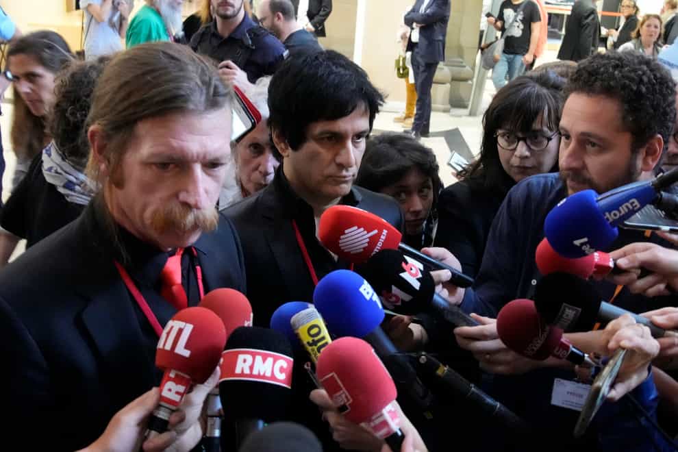 Eagles Of Death Metal singer Jesse Hughes, left, and guitarist Eden Galindo, centre, answer reporters questions (Christophe Ena/AP)