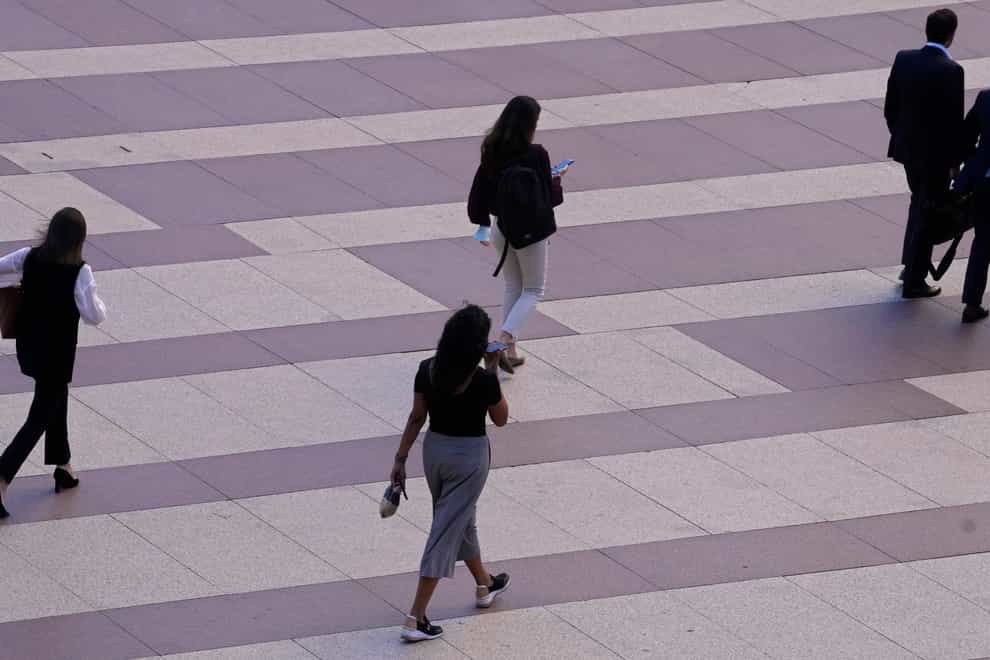 Women walk towards an office building in Madrid, Spain (Paul White/AP)