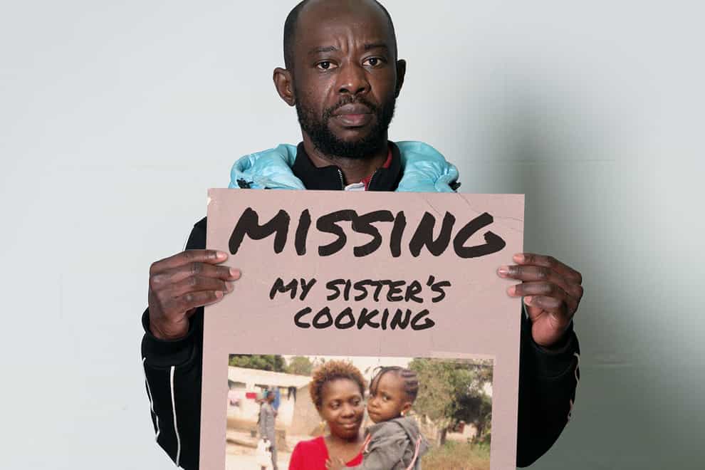 Siki pictured holding a missing poster, with a picture of his sister and her daughter on it (Inzajeano Latif and Migrant Help/PA)