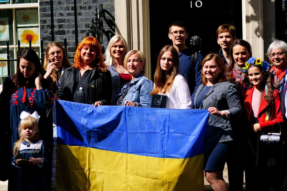 A number of Ukrainian families stand on the doorstep of 10 Downing Street after they met with Prime Minister Boris Johnson after arriving to the UK through the UK visa scheme (Victoria Jones/PA)