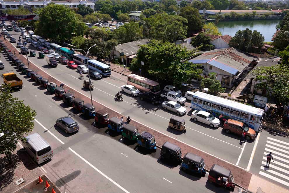 Motorists queue up to buy petrol near a fuel station in Colombo (AP)