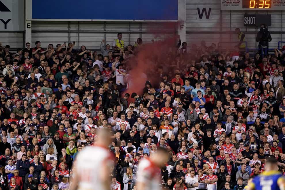 A flare is visible among the St Helens fans who packed the away end at The Halliwell Jones Stadium (PA Images/Zac Goodwin)