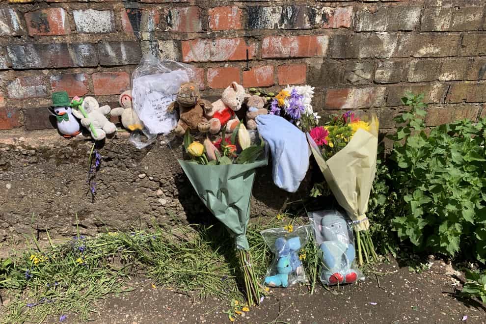 Floral tributes left near Rough Wood country park in Walsall, where a dead newborn boy was found in the local canal (PA)