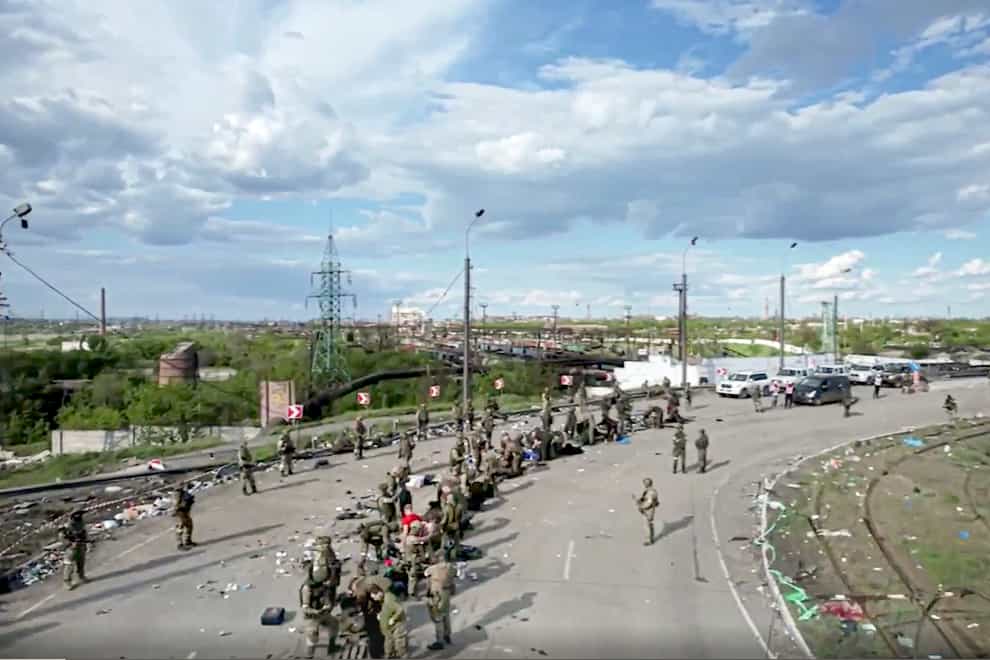 In this photo taken from video released by the Russian defence ministry, Ukrainian servicemen line up to be checked as they leave the besieged Azovstal steel plant in Mariupol (Russian Defence Ministry Press Service/AP)