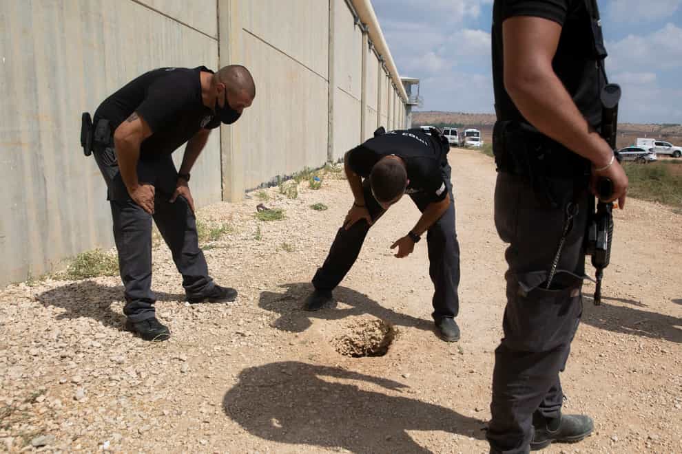 Police officers and prison guards inspect the scene of the escape (Sebastian Scheiner/AP)