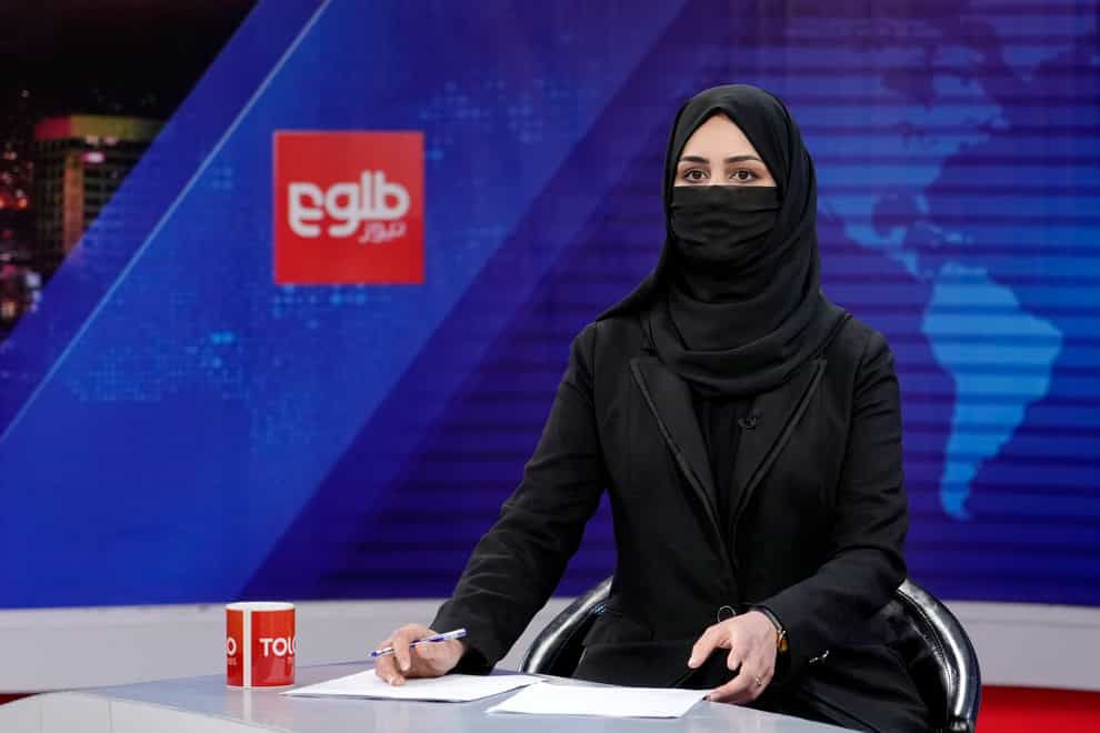 TV presenter Khatereh Ahmadi wears a face covering as she reads the news in Kabul on Sunday (Ebrahim Noroozi/AP)