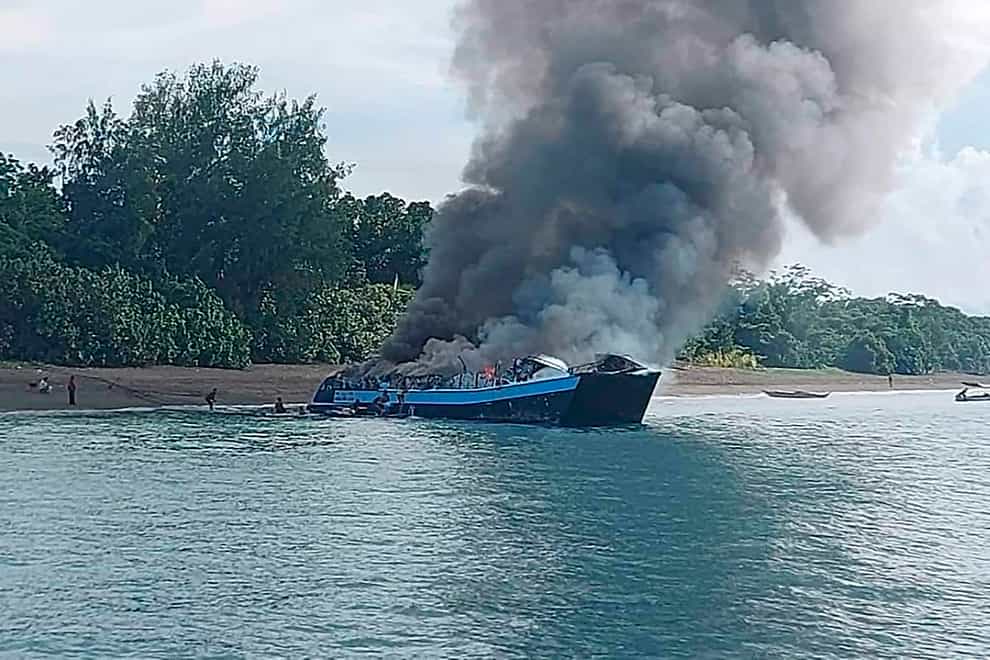Smoke billows from the M/V Mercraft 2 ferry as it is towed to an island off the town of Real, Quezon province, Philippines (Philippine Coast Guard via AP Photo)