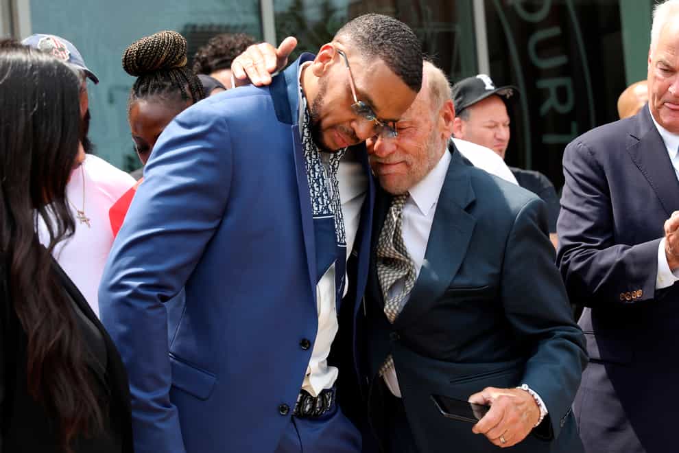 Grant Williams, left centre, is embraced by his lawyer Irving Cohen after his murder conviction is vacated (Jan Somma-Hammel/Staten Island Advance/AP)