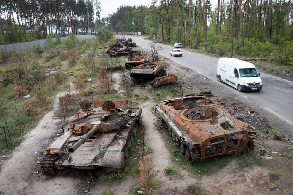 Cars pass by destroyed Russian tanks in a recent battle against Ukrainians in the village of Dmytrivka, close to Kyiv, Ukraine, Monday, May 23, 2022. (AP Photo/Efrem Lukatsky)