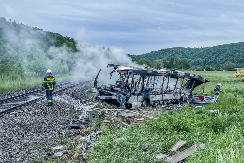 Firefighters extinguish a blaze which completely destroyed the bus (dpa via AP)