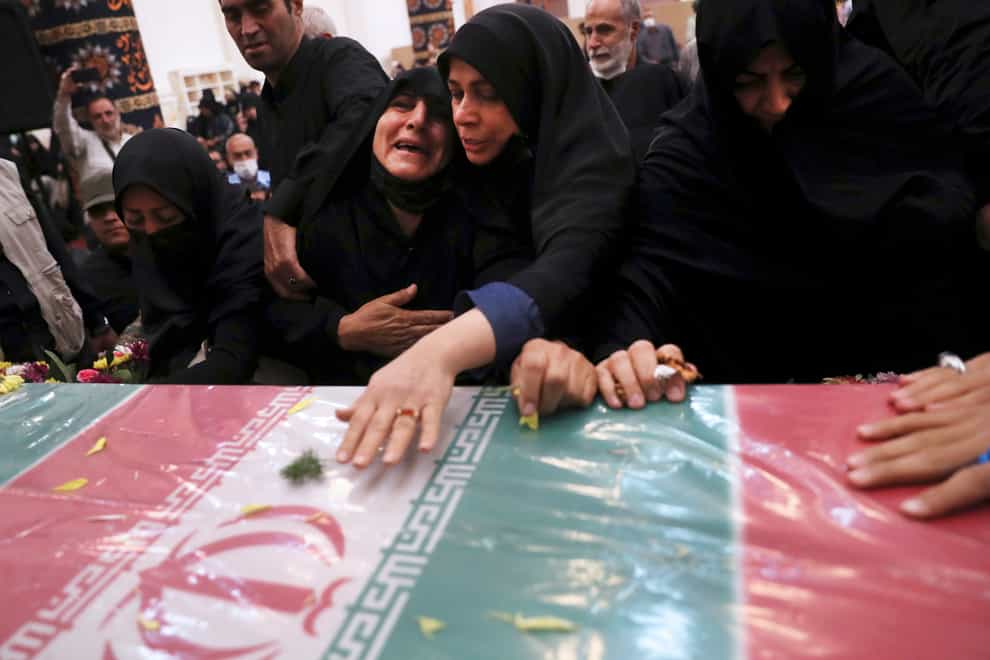 Relatives mourn over the flag draped coffin of Iran’s Revolutionary Guard Col. Hassan Sayyad (AP)