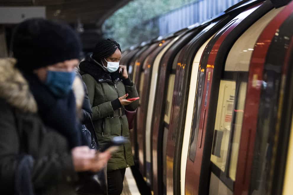 Commuters getting on a Jubilee Line Underground train at Canning Town station during the morning rush hour in London, as England’s third national lockdown to curb the spread of coronavirus continues (PA)