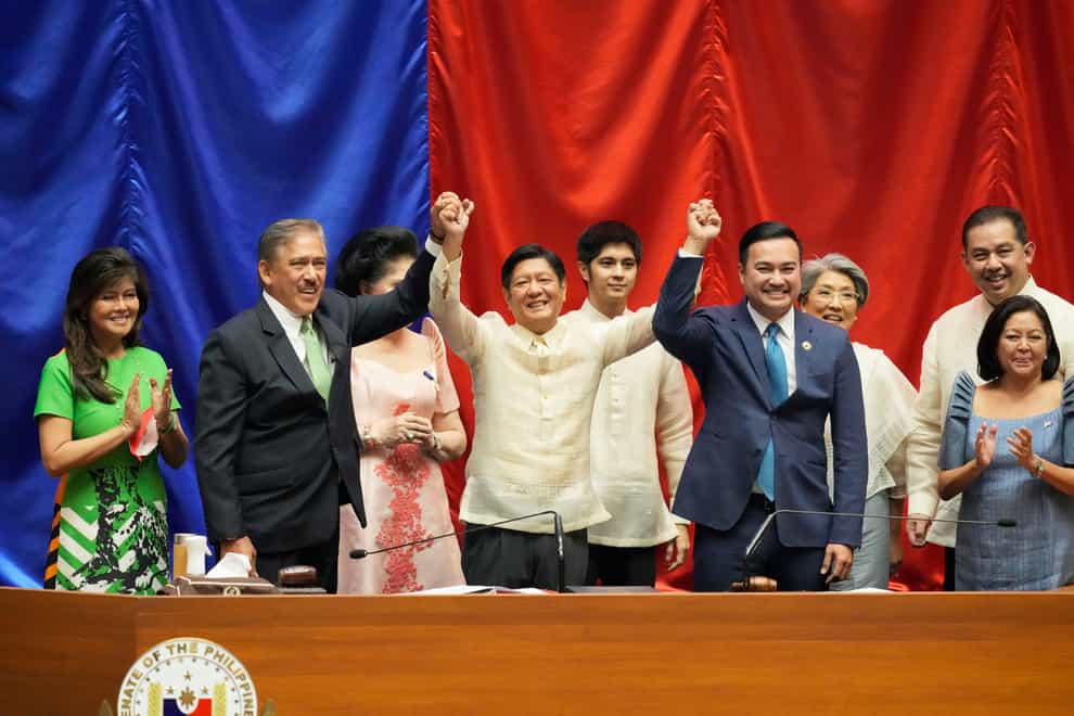 Ferdinand Marcos Jr, centre, raises hands (AP Photo/Aaron Favila)