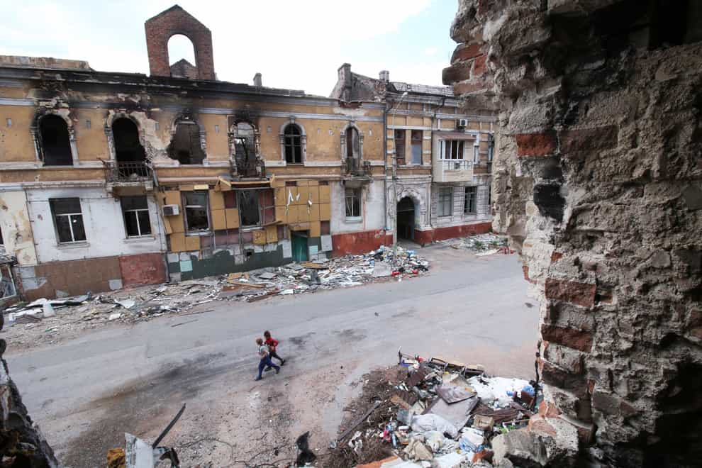 Children walk among buildings destroyed during fighting in Mariupol in Ukraine (AP)