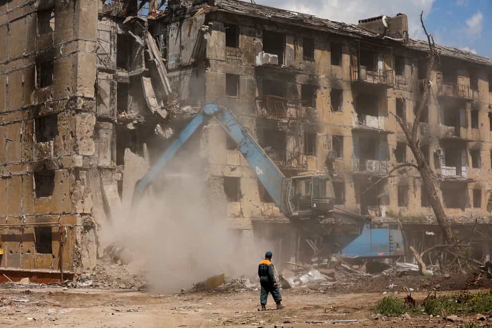 Russian Emergency Situations Ministry workers disassemble a destroyed building in Mariupol (AP)