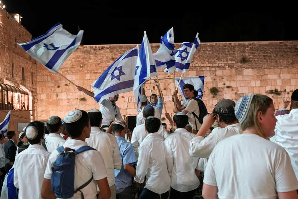 Members of Jewish youth movements dance and wave Israeli flags on the eve of Jerusalem Day, an Israeli holiday celebrating the capture of the Old City during the 1967 Middle East war, next to the Western Wall in Jerusalem (Tsafrir Abayov/AP)