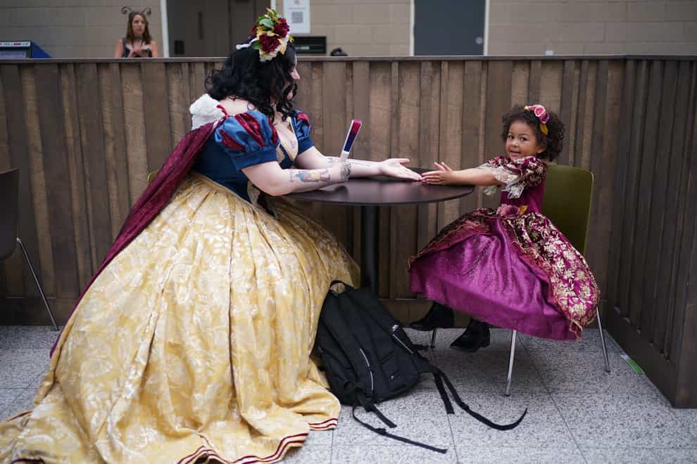 Mother and daughter cosplayers Revan Jordan, left, dressed as Snow White, and Bella, dressed as Rapunzel, during MCM Comic Con at the ExCel in London (Yui Mok/PA)