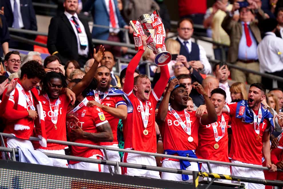 Nottingham Forest’s Joe Worrall lifts the play-off trophy and celebrates promotion to the Premier League (Mike Egerton/PA)