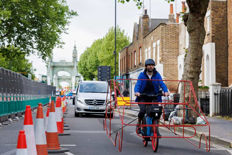 Cyclists wearing frames shaped like cars are taking to the streets of London to demonstrate that vehicles are ‘hogging’ roads (Dott/PA)