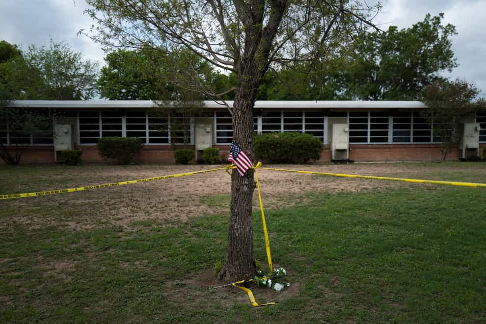 A school building stands behind a tree with an American flag and crime scene tape at Robb Elementary School in Uvalde, Texas (Jae C. Hong/AP)