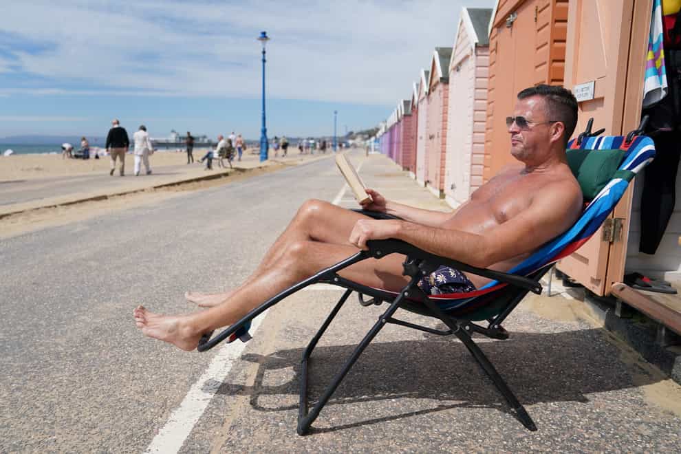 Stuart Henderson enjoys sunshine from his beach hut on Bournemouth beach (PA)