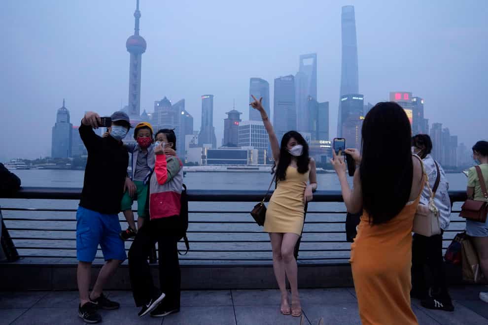 Residents pose for photos along the Bund (AP)