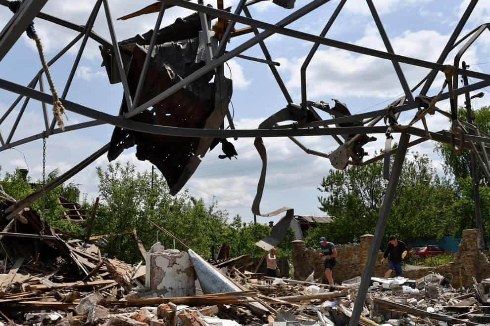 People clean an area of a building damaged by an overnight missile strike in Sloviansk, Ukraine (AP)