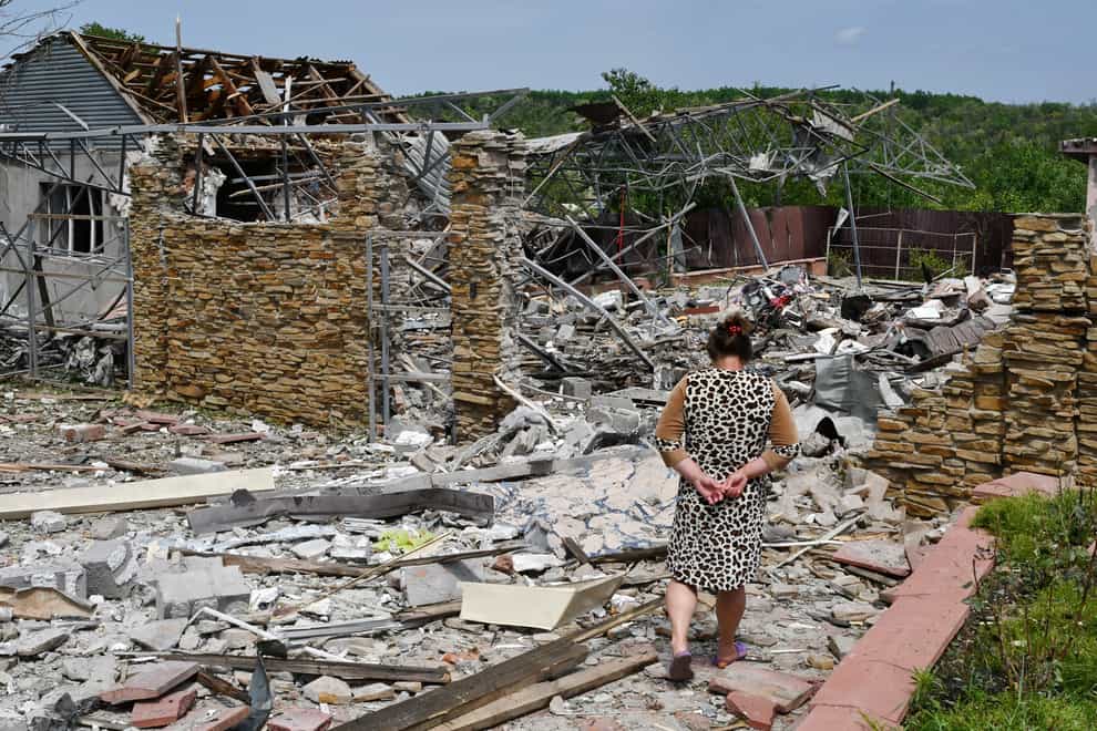 An elderly woman walks next to a building damaged by an overnight missile strike in Sloviansk (AP)