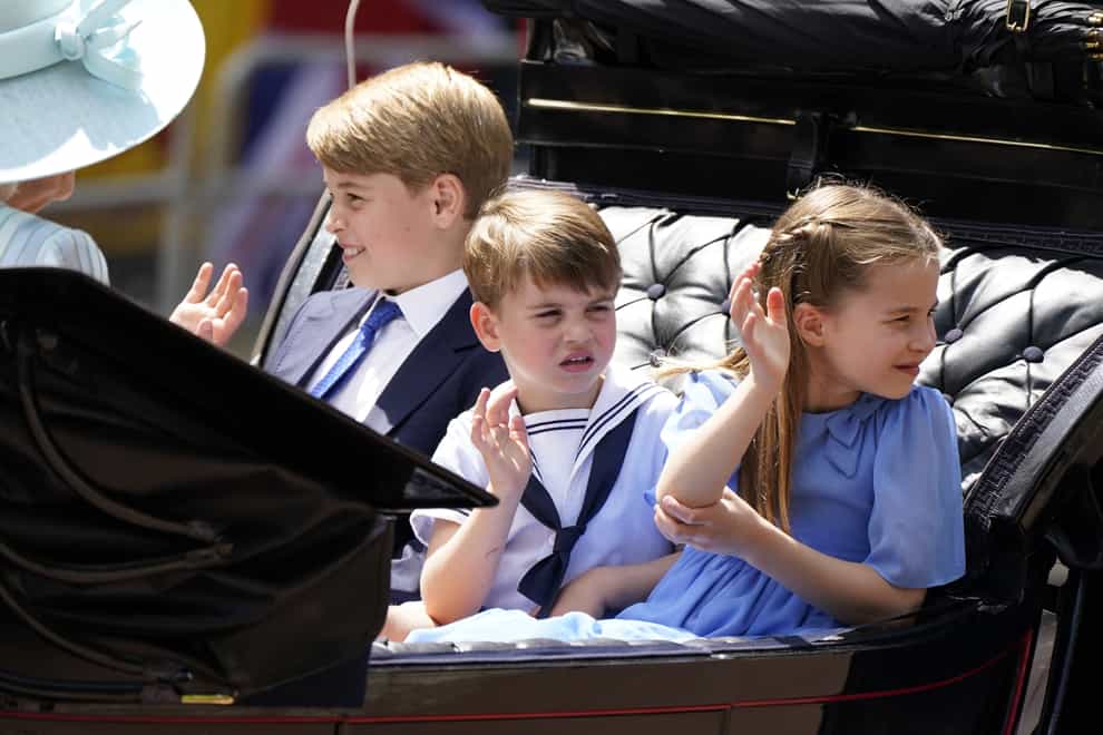 Prince George, left, Prince Louis and Princess Charlotte ride in a carriage (Andrew Matthews/PA)