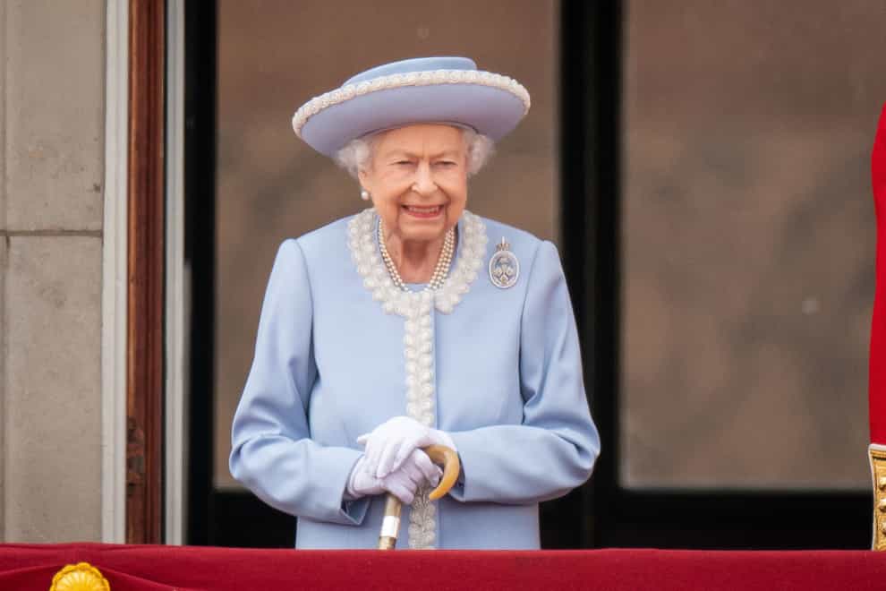 The Queen on the balcony at Buckingham Palace with her walking stick (PA)