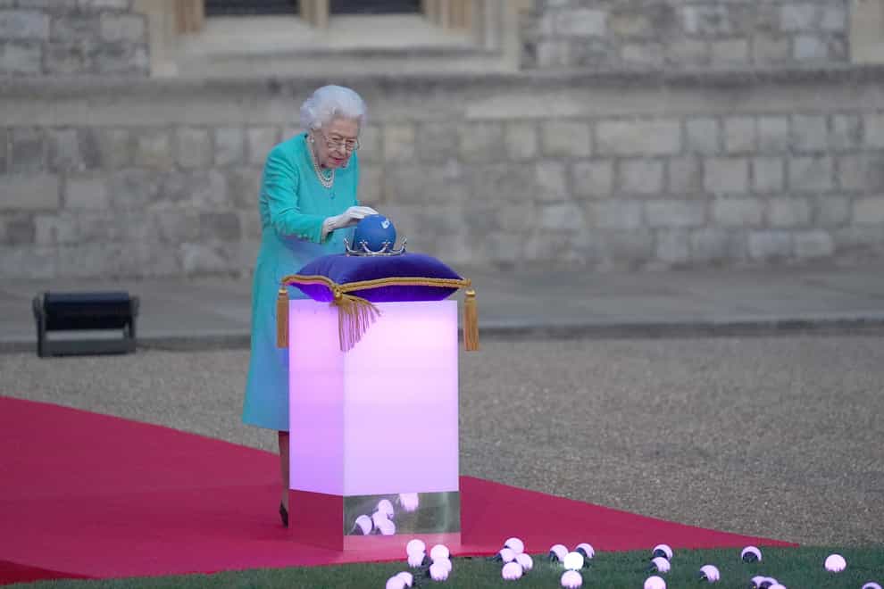 Queen Elizabeth II symbolically leads the lighting of the principal Jubilee beacon at Windsor Castle, as part of a chain of more than 3,500 flaming tributes to her 70-year-reign (Steve Parsons/PA).