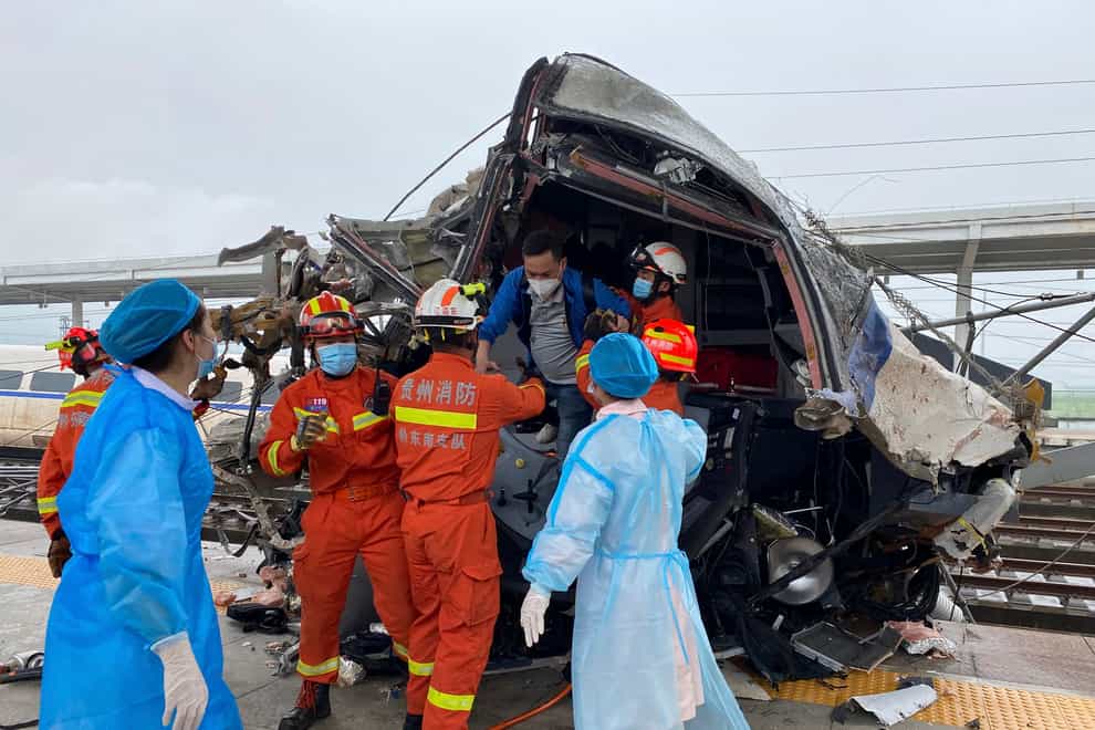 Emergency personnel help a passenger off a damaged train car after it derailed in Rongjiang County in south-west China’s Guizhou Province (Xinhua/AP)
