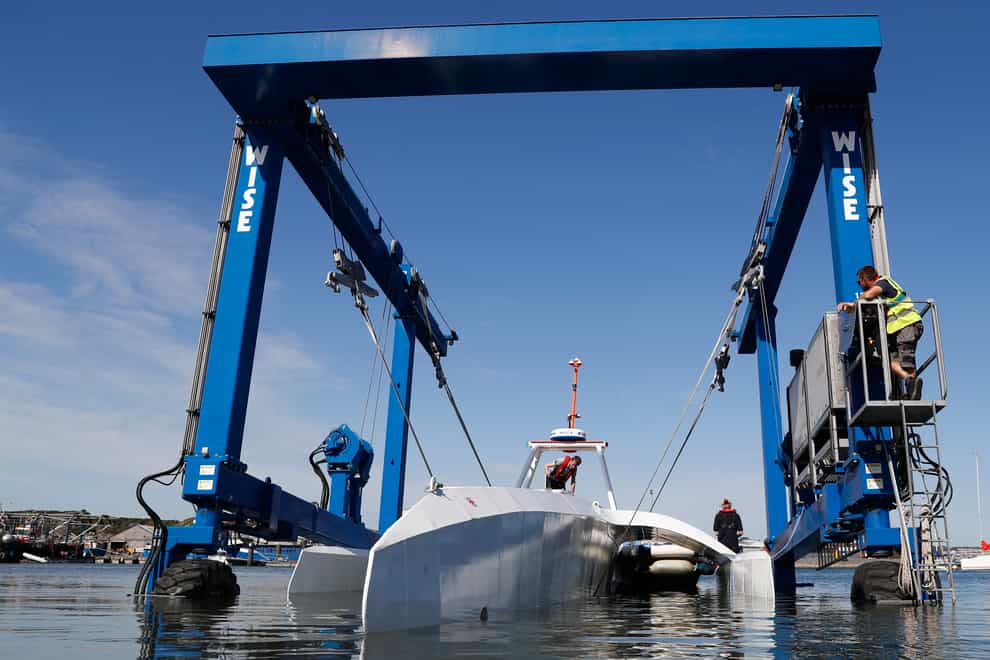 Technicians lower the Mayflower Autonomous Ship into the water at its launch site (Alastair Grant/AP)