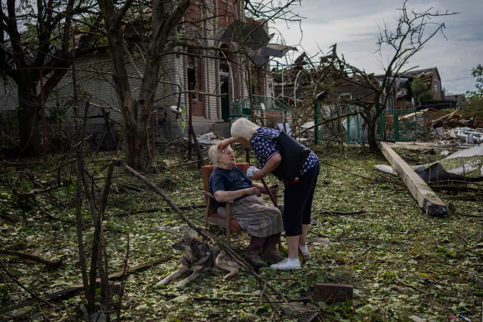 A woman sits among debris outside her house damaged after a missile strike in Druzhkivka, eastern Ukraine (Bernat Armangue/AP/PA)
