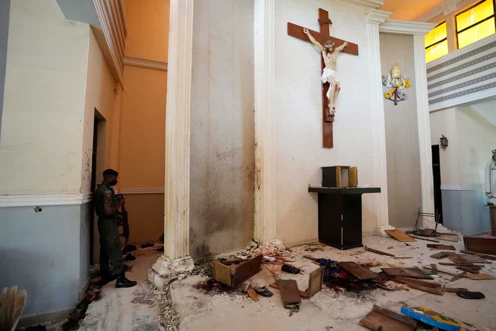 A police officer stands guard inside St Francis Catholic Church (Sunday Alamba/AP)