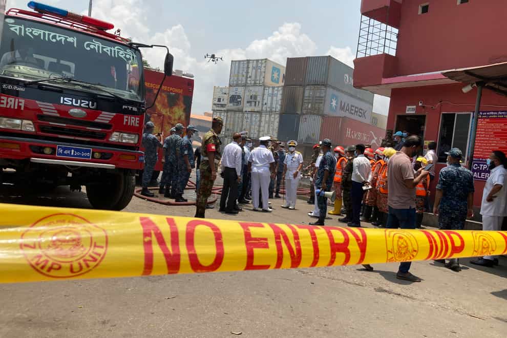 Military personnel and officials stand at the BM Inland Container Depot, where a fire broke out on Saturday in Chittagong (Al-emrun Garjon/AP)