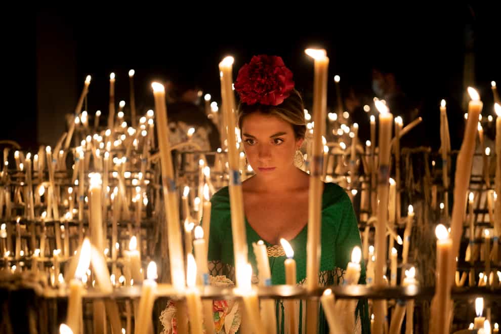 A pilgrim lights a candle in the sanctuary of the virgin of the Rocío (Joan Mateu Parra/AP)