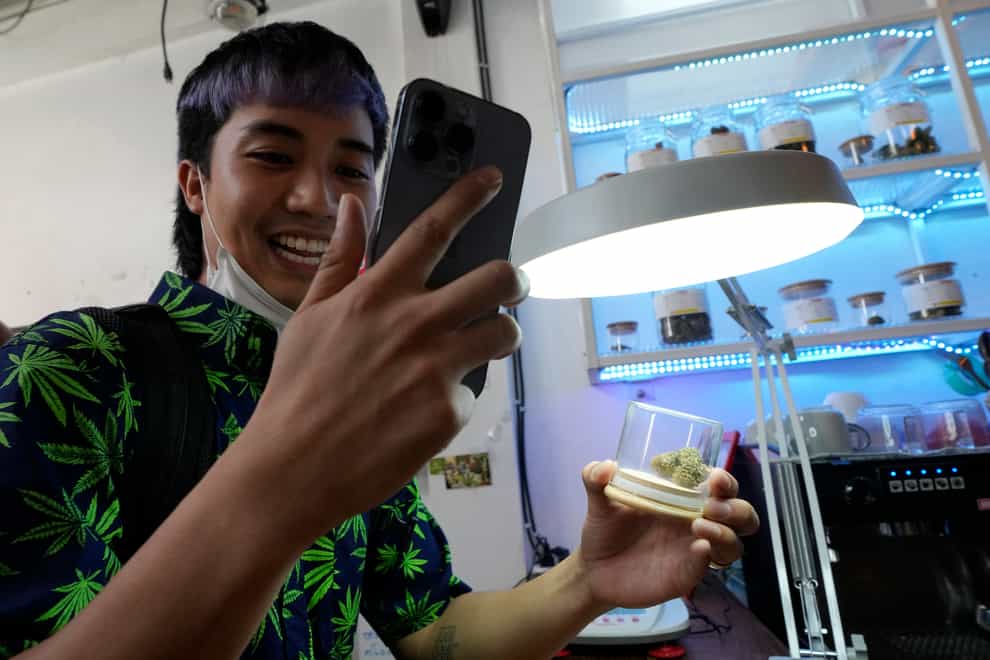 A customer talks on his mobile phone as he buys marijuana at the Highland Cafe in Bangkok, Thailand (Sakchai Lalit/AP)