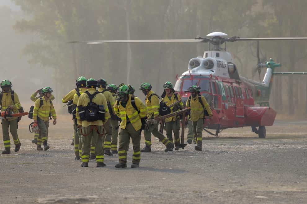Firefighters walk in the area of a wildfire in Pujerra, Malaga (Alex Zea, Europa Press via AP)