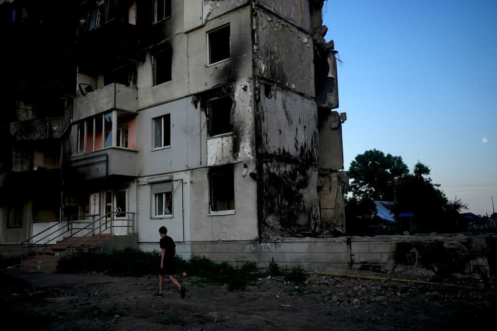 A man walks in front of a building destroyed by attacks in Borodyanka, on the outskirts of Kyiv (AP)