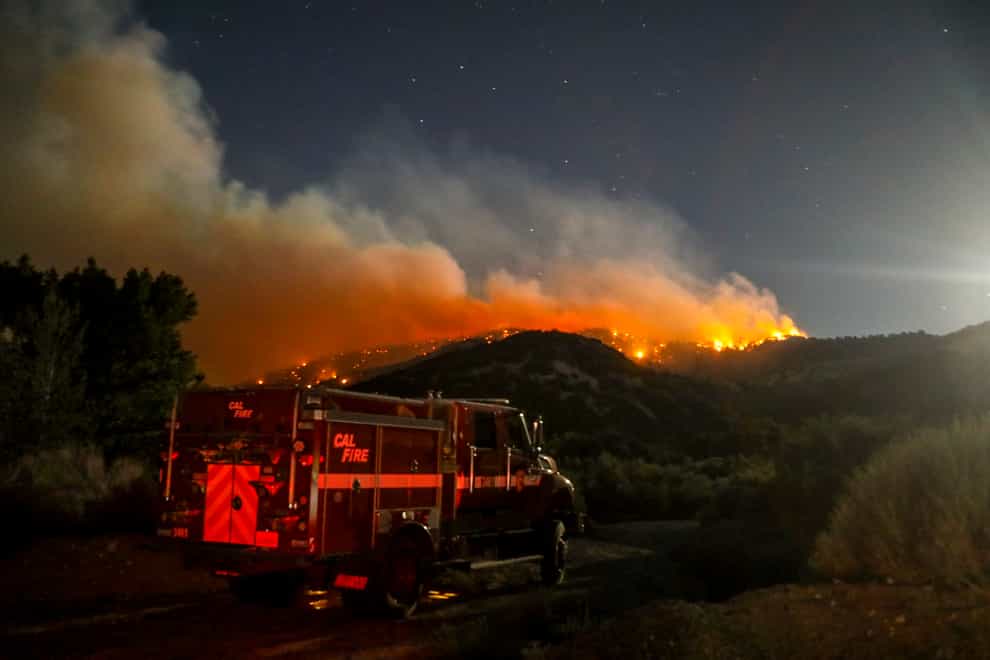 A fire engine is seen as the Sheep fire burns in Wrightwood, Calif., Monday, June 13, 2022. (AP Photo/Ringo H.W. Chiu)