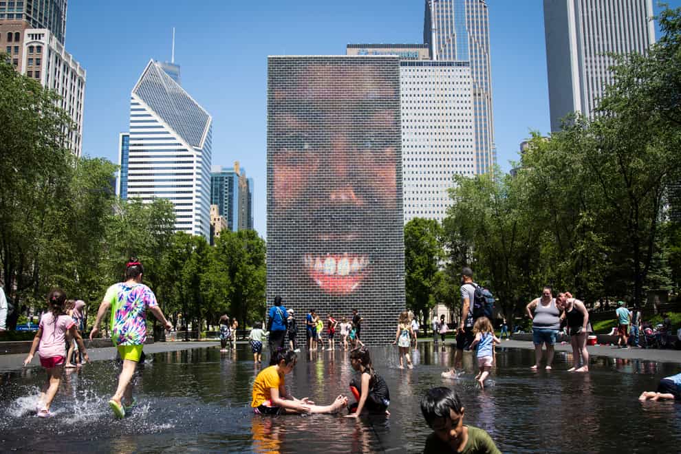 Children play in a fountain in Chicago as temperatures soared (Ashlee Rezin/Chicago Sun-Times via AP)